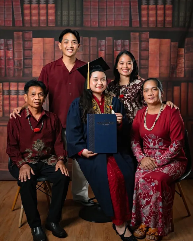 A family of five posing in the studio's library set