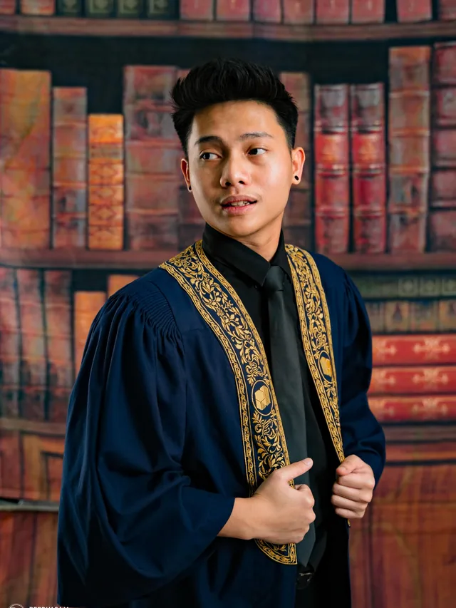 Graduate in a navy gown in BerduaSaja Studio's library set