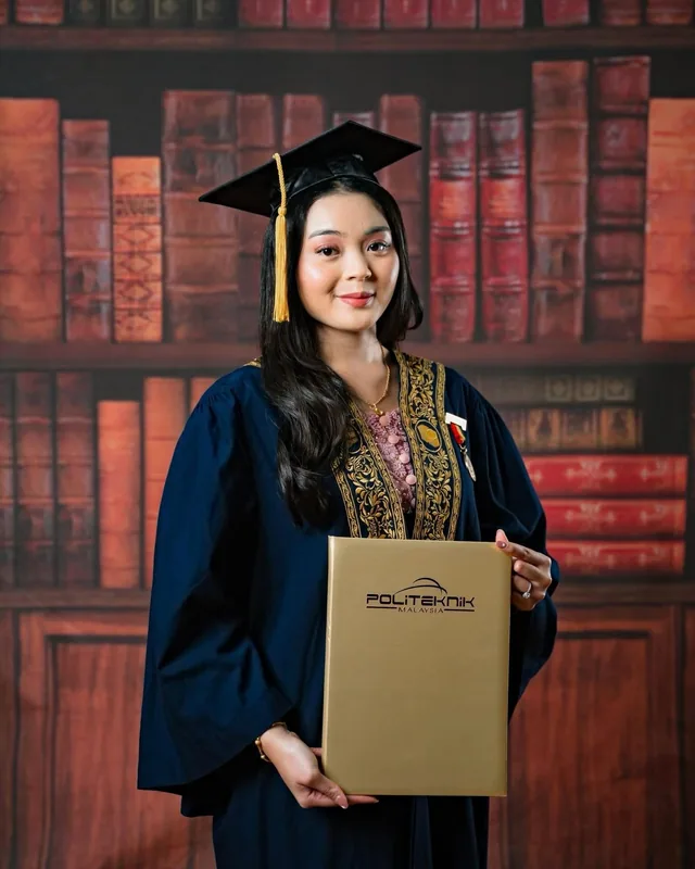 Graduate in a navy gown holding her scroll